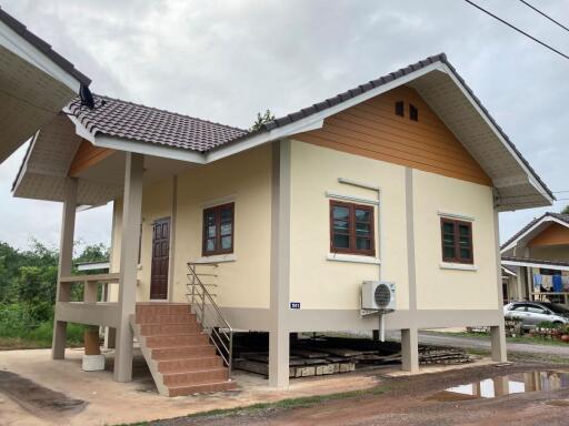 Elevated single-story house with external stairs and a sloped roof