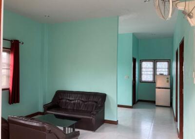 Living room with black leather sofas and a view into the kitchen