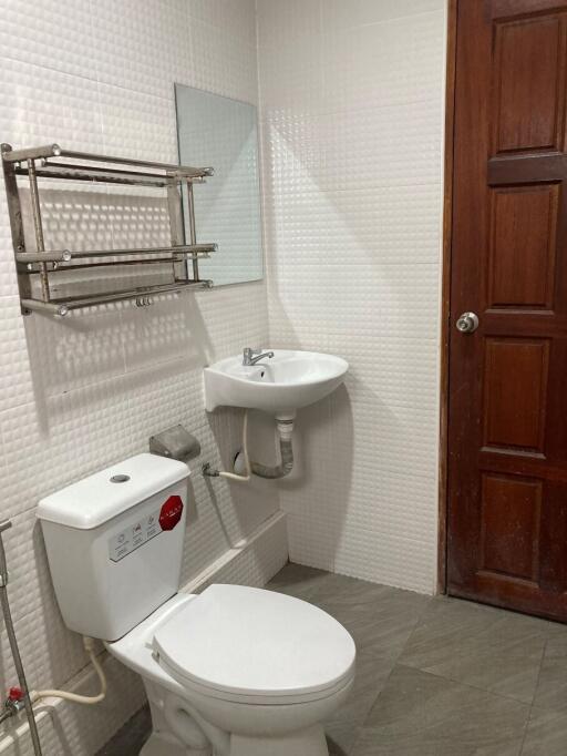 Small bathroom with toilet, sink, and door