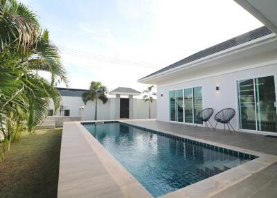 Outdoor swimming pool with surrounding modern house