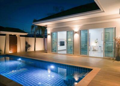 Modern house exterior with pool at night