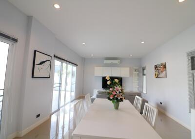 Modern dining area with white table and flowers