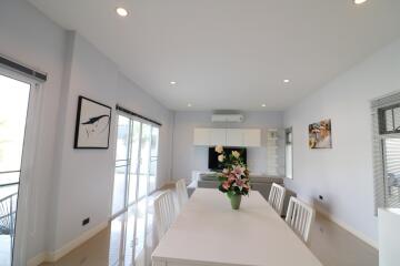 Modern dining area with white table and flowers