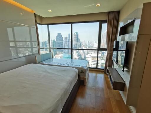 Modern bedroom with large windows offering city view