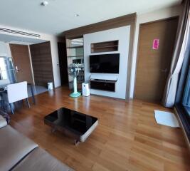 Modern living room with hardwood floors, entertainment center, and dining area