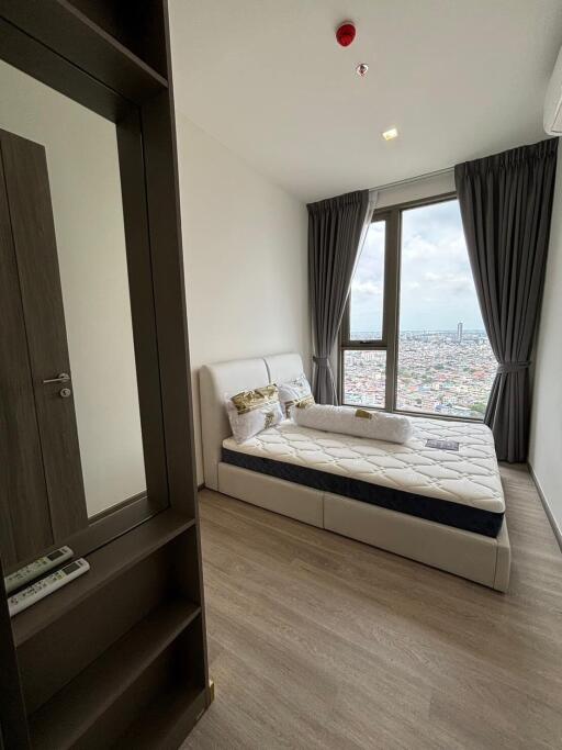 Modern bedroom with large window and city view