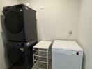 Laundry room with stacked washer and dryer, air conditioner unit, and white cabinet