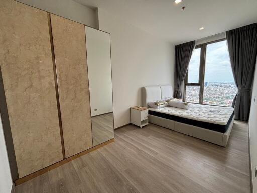 Spacious bedroom with large window and city view