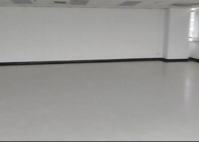 Spacious empty room with white walls and large windows