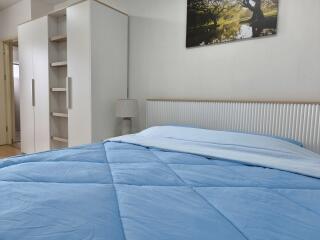 Modern bedroom with blue bedding and white furniture