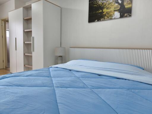 Modern bedroom with blue bedding and white furniture