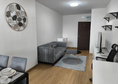 Modern living room with gray sofa and wall-mounted TV