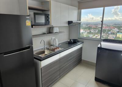 Modern kitchen with appliances and a large window providing city views