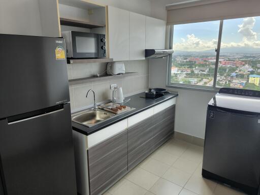 Modern kitchen with appliances and a large window providing city views