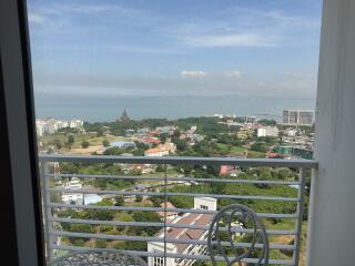 A balcony with a scenic view of the city and distant sea