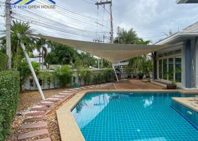 Beautiful poolside with tiled walkway and shade sail