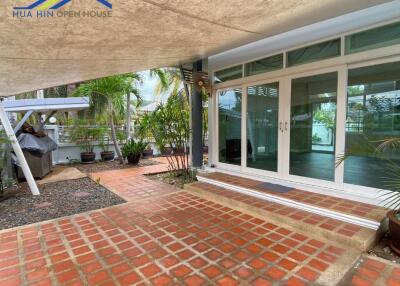 Outdoor patio area with tiled flooring and glass doors