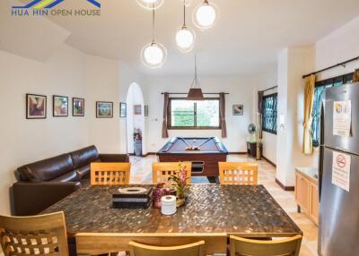 Spacious living room with a dining area, pool table, and modern furnishings