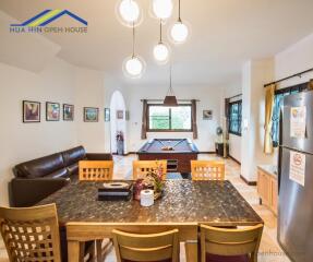 Spacious living room with a dining area, pool table, and modern furnishings