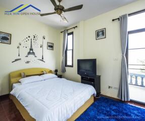 Cozy bedroom with a double bed, ceiling fan, and large windows