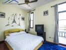 Cozy bedroom with a double bed, ceiling fan, and large windows