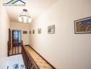 Well-lit hallway with framed artwork and a staircase