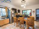 Modern kitchen with wooden dining set, stainless steel appliances, and large windows