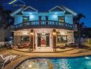 Two-story house with balcony, patio, and lit-up pool area at night