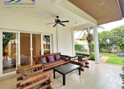 Outdoor patio with wooden seating area and ceiling fan