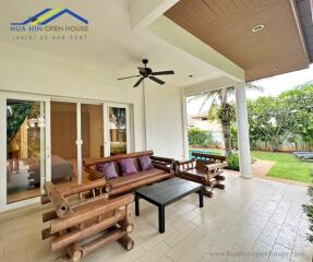 Outdoor patio with wooden seating area and ceiling fan