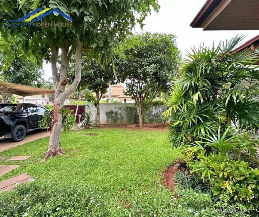 Well-maintained backyard garden with trees and greenery