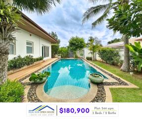 Swimming pool in a lush garden next to a modern house