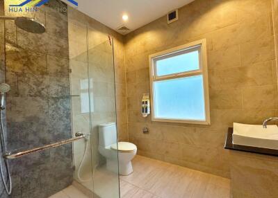 Modern bathroom with glass shower, toilet, and sink