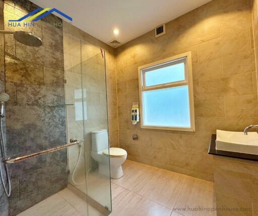 Modern bathroom with glass shower, toilet, and sink