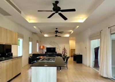 Modern kitchen and living area with island and ceiling fans