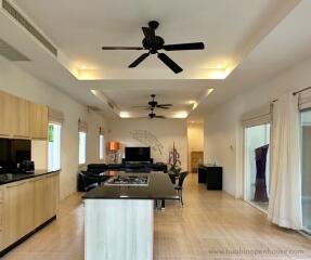 Modern kitchen and living area with island and ceiling fans