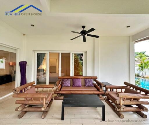 Outdoor seating area with wooden furniture and ceiling fan