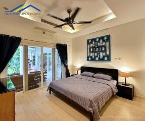 Modern bedroom with a large bed, ceiling fan, and sliding glass doors to the patio