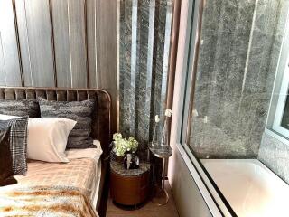 A modern bedroom with a view of a bathroom featuring a bathtub