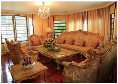 Elegantly furnished living room with chandelier and large windows