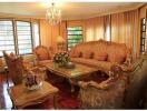 Elegantly furnished living room with chandelier and large windows