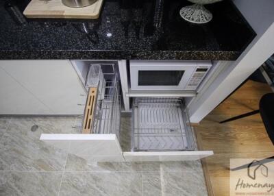 Modern kitchen with dishwasher, microwave, and granite countertop