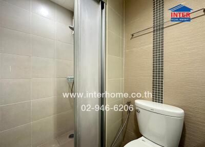 A bathroom with a shower enclosure and a toilet