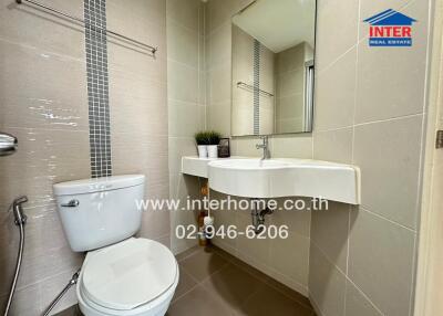 Modern bathroom with toilet, sink, and mirror