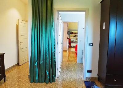 Bedroom with a green curtain leading to an adjacent room