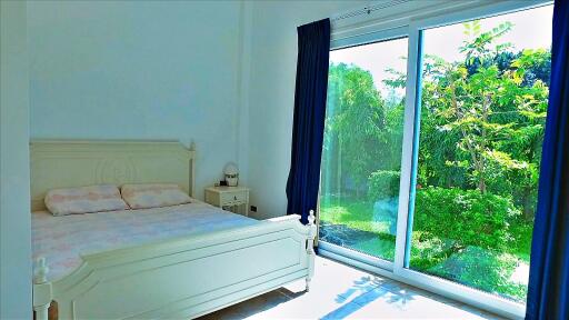 Spacious bedroom with large window and garden view