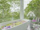 Luxurious bathroom with garden view and bathtub filled with flower petals