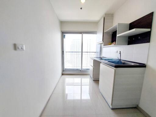 Modern kitchen with white cabinets and a balcony view