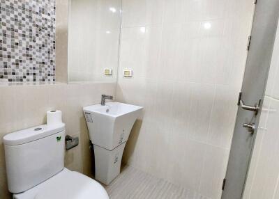 Modern bathroom with mosaic tiled wall and white fixtures