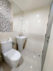 Modern bathroom with mosaic tiled wall and white fixtures